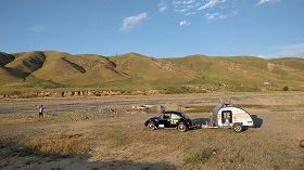 teardrop caravan being towed across a field 